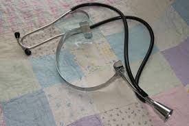 Manual Fetoscope to listen to baby's heartbeat. Curved part is placed on nurse's head for conduction.